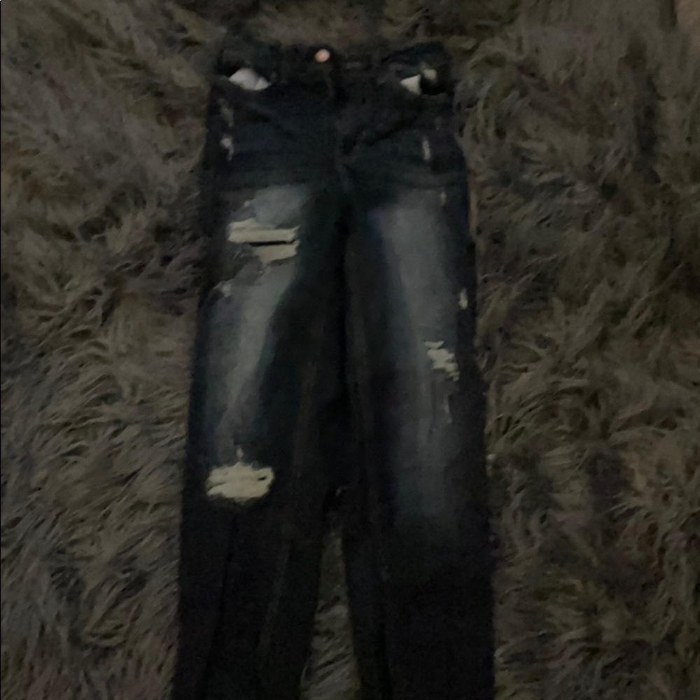 Dark blue high rise pants with holes up the legs.
